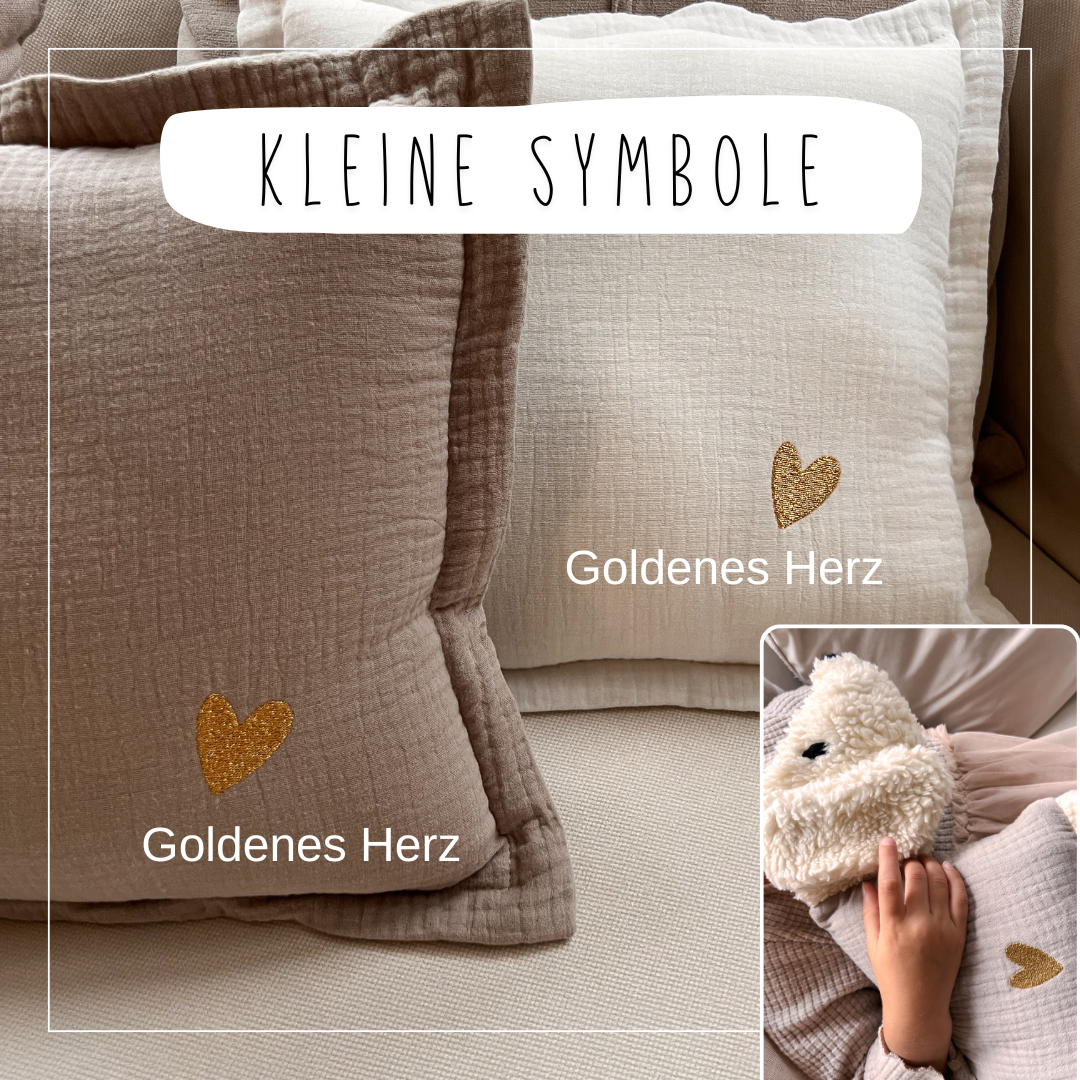 Kuschelschafe mit einem kleinen goldenen Herz als Stickmotiv auf dem Stoffkörper.