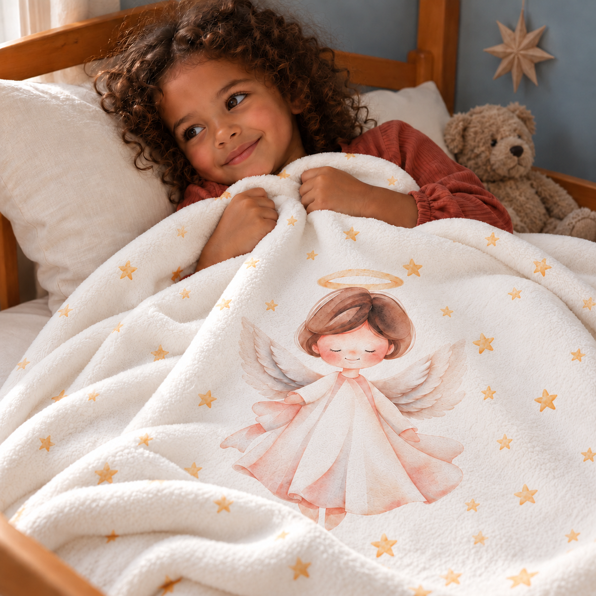 A child in bed under the “Christmas Angel” plush blanket.