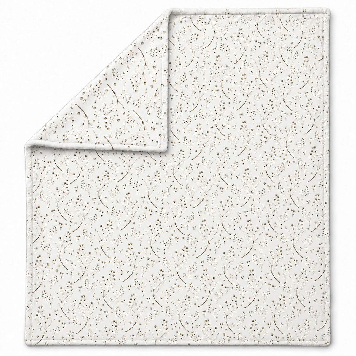 Ausgebreitete Kuscheldecke „Feine Zweige“ mit umgeschlagener Ecke auf weißem Hintergrund.