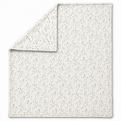 Ausgebreitete Kuscheldecke „Feine Zweige“ mit umgeschlagener Ecke auf weißem Hintergrund.