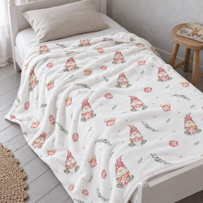 Kuscheldecke „Weihnachtself“ auf einem Bett ausgebreitet.