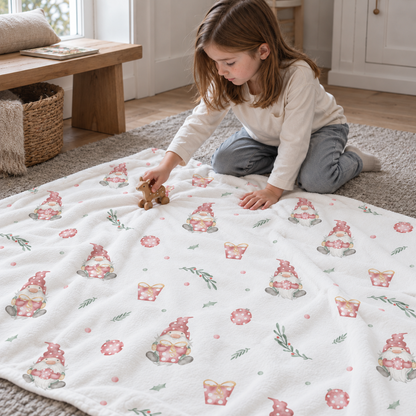 Kind spielt am Boden mit der Kuscheldecke „Weihnachtself“.