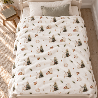 Kuscheldecke „Winterwald“ auf einem Bett ausgebreitet.